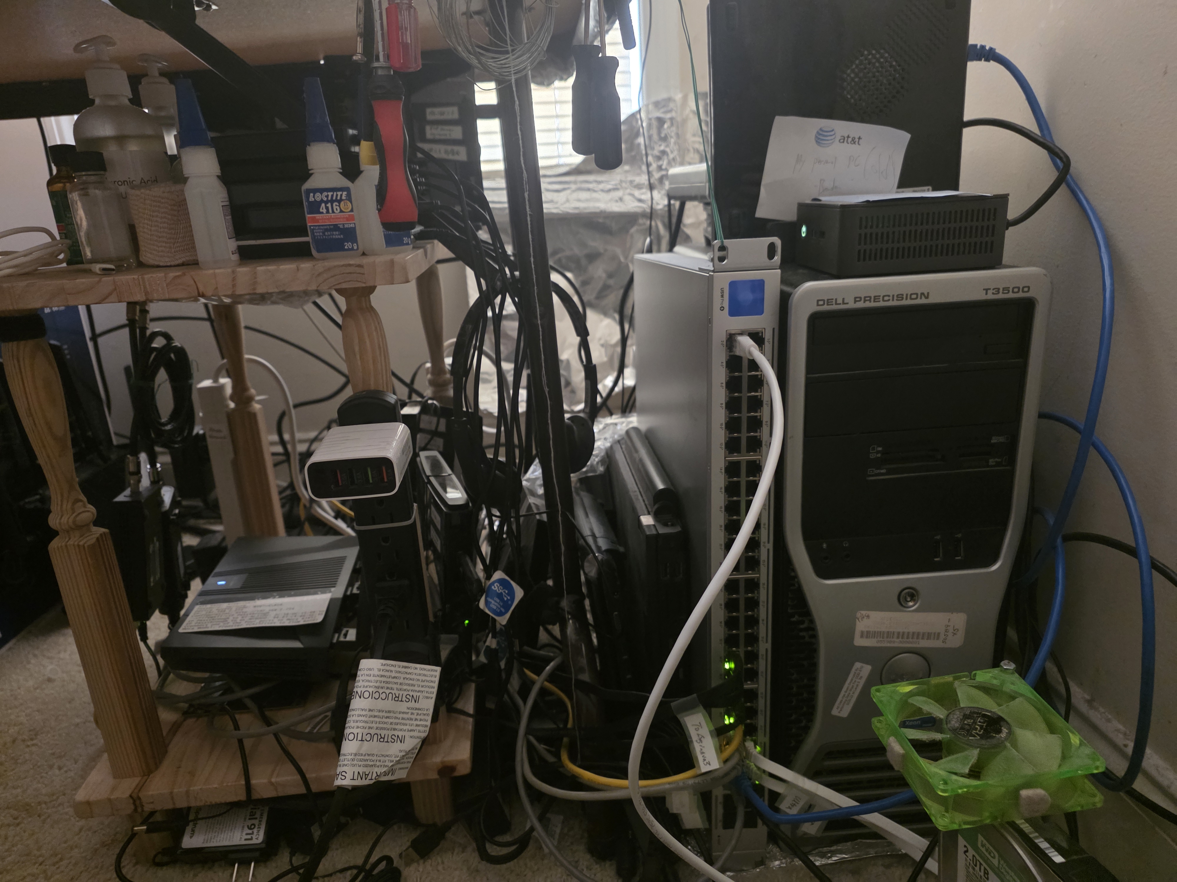 My homelab, with an ethernet cable running to a switch and some mini PCs stacked up